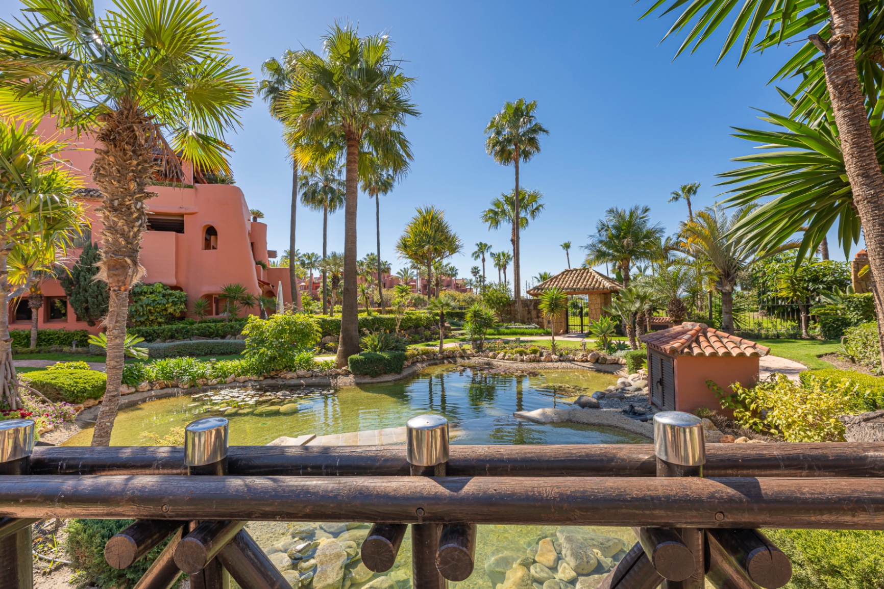 Tropical palm gardens and traditional Andalusian architecture inside a Marbella resort community.